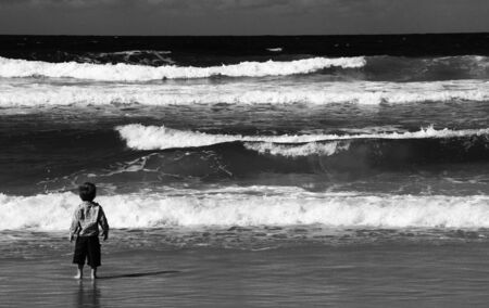 3-year-old looks at the sea  Autumn sea, strong waves, sharp colors の写真素材