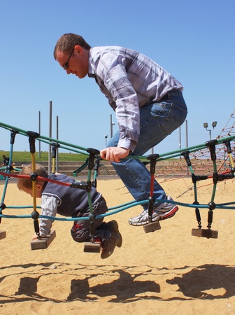 boy with his father on playgroundの写真素材