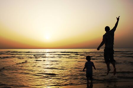 Father and son at sunset on the seaの写真素材