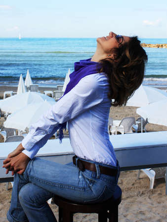 A girl sits alone in a cafe and looking at the skyの写真素材