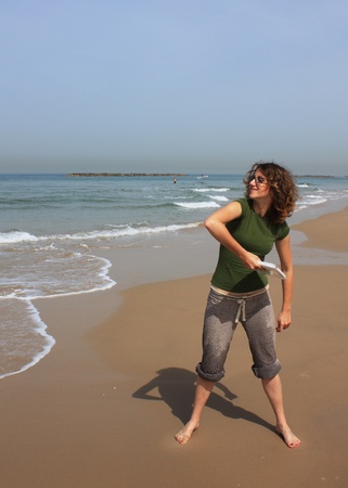 girl wants to throw in the sea her white small laptopの写真素材