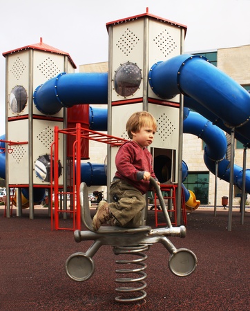 2 year old child sitting on a motorcycle on the playgroundの写真素材