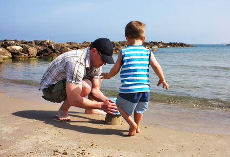 father and son playing on the beachの写真素材