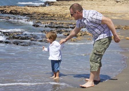 father and son playing on the beachの写真素材