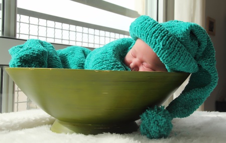 newborn in a knitted cocoon and hatの写真素材