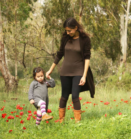 Mother and daughter in a field of red poppiesの写真素材