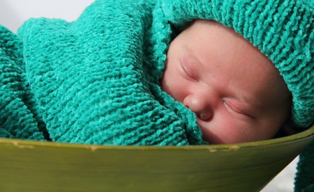 newborn in a knitted cocoon and hatの写真素材