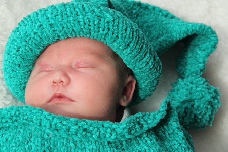 newborn in a knitted cocoon and hat の写真素材
