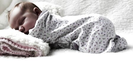 Monthly Redhead girl sleeping on a white blanketの写真素材