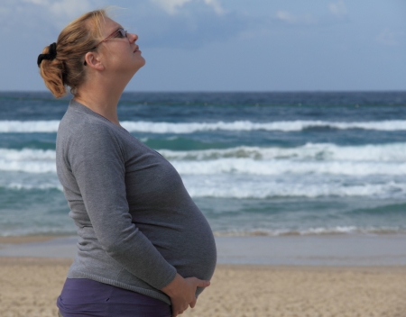 pregnant woman relaxing on the beachの写真素材