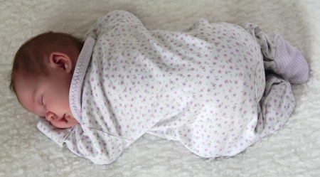 monthly child lies on a white blanketの写真素材