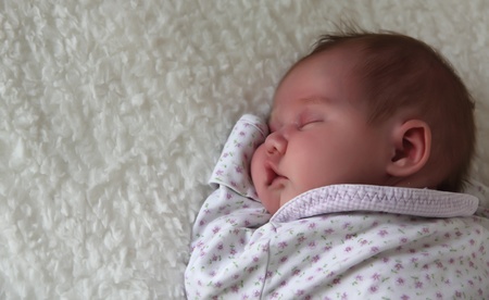 monthly child lies on a white blanketの写真素材