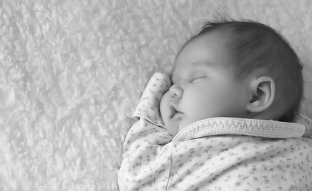 monthly child lies on a white blanketの写真素材