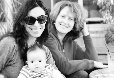 two beautiful girls with a baby outdoorの写真素材
