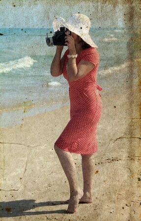 Beautiful photographer on the beach  Photo in old image style の写真素材