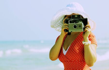 young girl in red dress with old cameraの写真素材