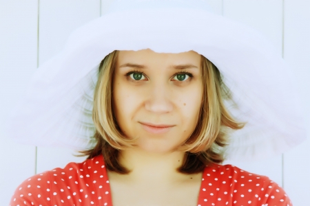 Portrait of young woman in red dress and white hat の写真素材