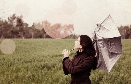 Young woman with umbrella in old color image style の写真素材