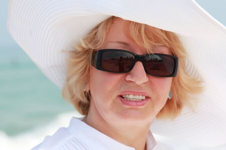 happy senior woman on summer vacation at seaの写真素材