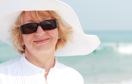 happy senior woman on summer vacation at seaの写真素材
