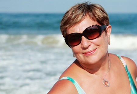 happy senior woman on summer vacation at seaの写真素材