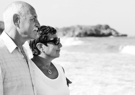 Happy senior couple walking together on a beachの写真素材