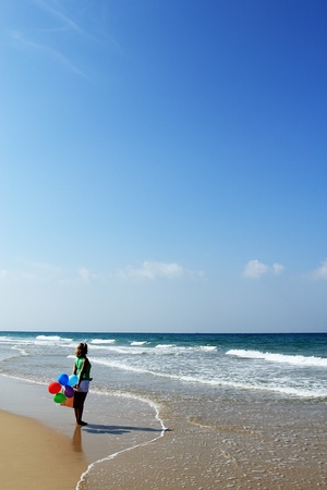 beautiful girl with the balloons came to vacation at seaの写真素材