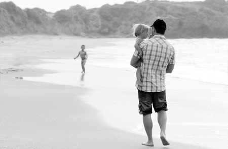 father with two kids on vacation at sea on sunset coloursの写真素材