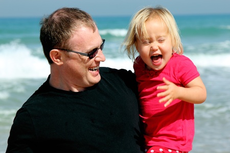 Portrait of father and daughter on the beachの写真素材