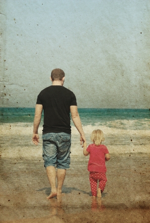 father and daughter on the beach. Photo in old image style.の写真素材