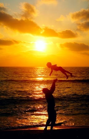 father and son on the sea at sunsetの写真素材