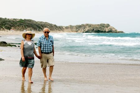 Happy elderly couple enjoying their retirement vacation near the seaの写真素材