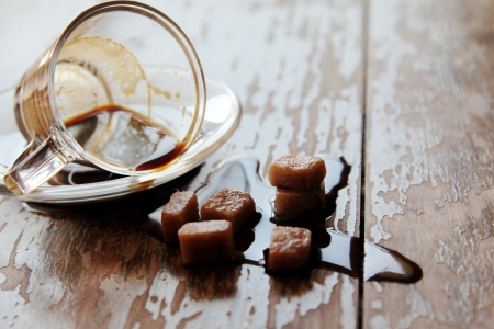 spilled coffee cup on wooden tableの写真素材