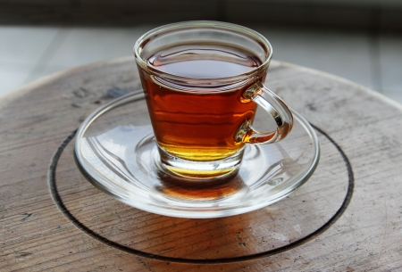 cup of tea standing on small wooden tableの写真素材
