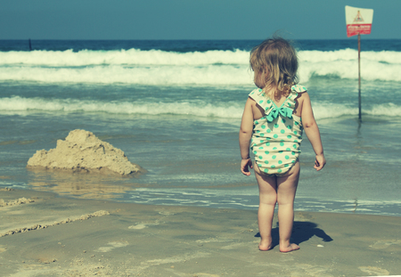 little girl on blue sea shore in summer vacationの写真素材