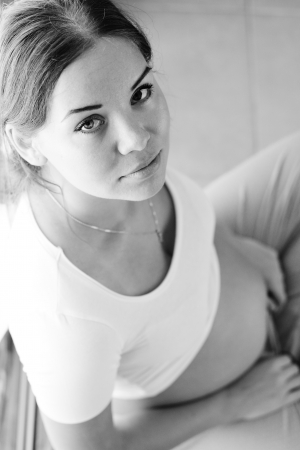 pregnant sad woman at homeの写真素材