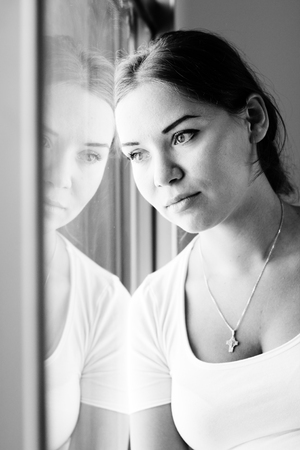 beautiful woman sitting in front of the windowの写真素材