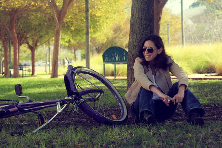 woman with retro bicycle in a park on early spring timeの写真素材