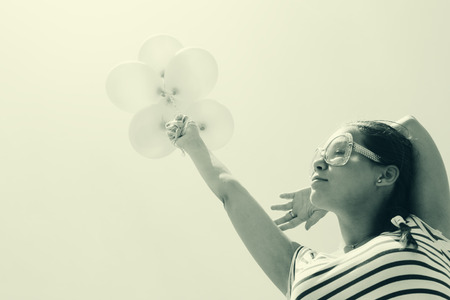 beautiful woman with colorful balloons outsideの写真素材