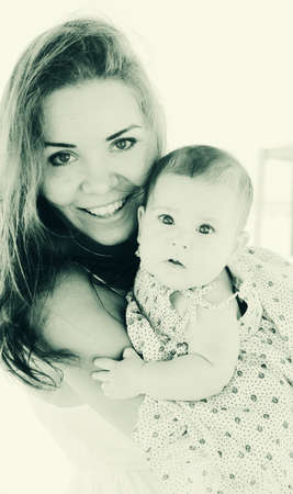 Portrait of happy loving mother and her baby at the beachの写真素材