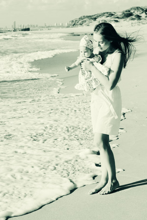 portrait of young mother and her cute baby on the seasideの写真素材