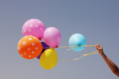 beautiful woman with colorful balloons on seaside