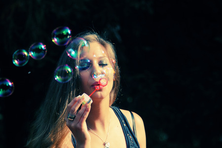 pretty girl blowing bubblesの写真素材