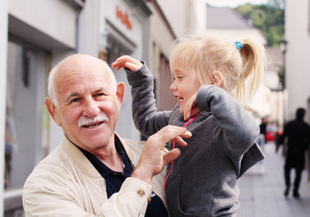 grandfather holding his 3 year old granddaughterの写真素材