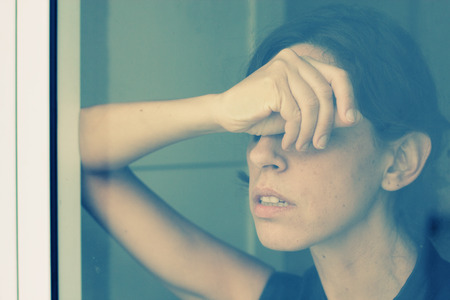 beautiful 35 year old woman stands in front of the windowの写真素材