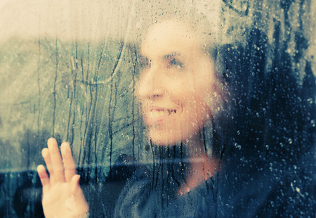 beautiful woman stands in front of the windowの写真素材