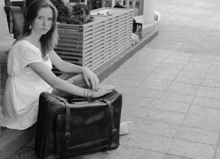 beautiful woman with vintage bag outdoorsの写真素材