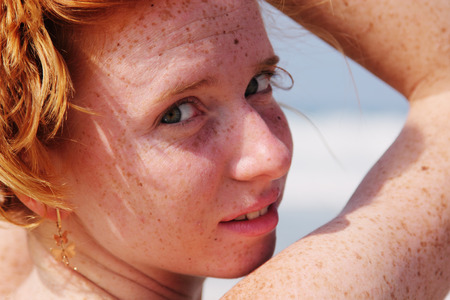 Beautiful readhead woman at the beachの写真素材