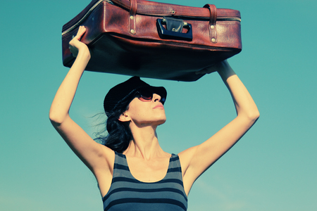 Woman with vintage bag standing in the fieldの写真素材