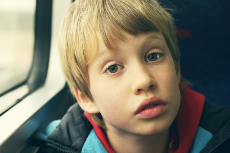 Cute Boy looking through the windowの写真素材